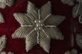 A closeup of an antique embroidered red velvet pillow