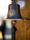 Closeup of antique rusty bell on stucco wall