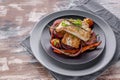 Closeup appetizing cod filet with red onion and herbs: sage, rosemary and thyme, baked potatoes and carrots on a side dish in a