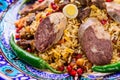 Closeup of an appetizing Uzbek national dish Plov, Pilaf made of rice and meat served with peppers