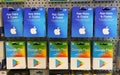 Closeup of Apple app store iTunes and Google Play voucher gift Cards in a row in shelf of german shop