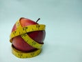 Closeup of an Apple with a measuring tape symbolizing the Weight loss concept and healthy diet. Royalty Free Stock Photo