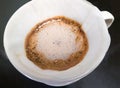 The closeup of the arabica ground coffee in the process of brewing from pouring hot water