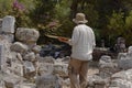 Closeup of a Archaeologist in a Greek ruin analyzing and evaluating the excavations