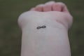 Closeup of the arm with an infinity symbol tattooed in his wrist. infinity sign on the hand. endless love concept Royalty Free Stock Photo