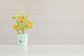 Closeup artificial orange plant with orange fruit in green pot on blurred wooden desk and wall textured background in office room