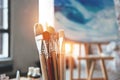 Closeup of artist paintbrushes and studio interior. Blurred background. Workshop or art class. Creative concept