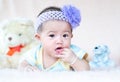 Closeup asian baby infant laying comfortably on bed playing with bear doll on softness cushion,Baby development concept