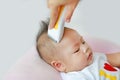 Closeup Asian infant baby boy getting a haircut Royalty Free Stock Photo