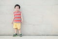 Closeup asian kid do not look satisfied with something on marble stone wall textured background with copy space Royalty Free Stock Photo