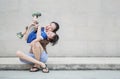 Closeup asian mother holding her son in fun motion on brick wall textured background with copy space Royalty Free Stock Photo