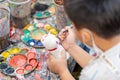 Closeup Asian primary students holding paint brush study and learning paint on plaster doll in the art classroom Royalty Free Stock Photo