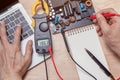 Closeup asian technician man hand measuring electrical voltage of computer mainboard by using digital multimeter. Royalty Free Stock Photo