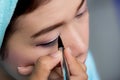 Closeup asian woman applying eyeliner on eye Royalty Free Stock Photo