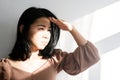 Asian woman covering her face and eye from sunlight worried to have sunburn because of ultraviolet light Royalty Free Stock Photo