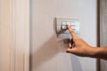 Closeup of Asian woman finger is turning off on grey light switch over textile texture wall in the hotel. Copy space. energy Royalty Free Stock Photo