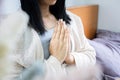 Closeup Asian woman hand praying ,meditating in bed