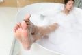 Closeup of asian woman`s feet covered with foam bubble bath Royalty Free Stock Photo