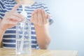 Closeup Asian woman wearing protective mask using hand sanitizer by pumping alcohol gel. Cleaning her hands with sanitizer gel. in Royalty Free Stock Photo