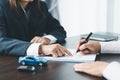 Closeup asian women people car saler or sales manager offers to sell a car and explains and reads the terms of signing a car