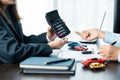 Closeup asian women people car saler or sales manager offers to sell a car and explains and reads the terms of signing a car