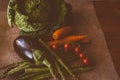 Closeup of asparagus, cabbage, carrots, eggplant, and tomatoes on a brown table cloth Royalty Free Stock Photo