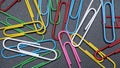 Closeup of assorted colorful paperclips isolated on black background Royalty Free Stock Photo