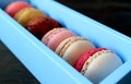 Closeup assortment of gorgeous colored Macaron pastries in a blue box