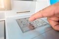 Closeup ATM machine and finger hand entering pressing password for withdrawing money banknotes