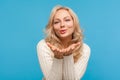 Closeup attractive blond woman in knitted sweater sending air kiss looking at camera, happy lady in love flirting