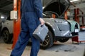 Closeup auto mechanic carrying bottle of oil for change