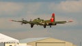 Closeup of B-17G flying fortress Texas Raiders shortly after take off over a hanger