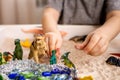 Closeup baby boy hands playing carnivorous and herbivorous dinosaurs with kinetic sand sensory box Royalty Free Stock Photo