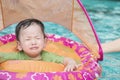 Closeup a baby boy sit in a boat for children in the swimming pool background in fear emotion Royalty Free Stock Photo