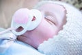 Closeup of a baby doll with closed eyes and pacifier Royalty Free Stock Photo