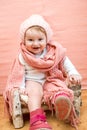 Closeup baby face in snood. Cute baby girl with blue eyes in a pink knitted hat and scarf on pink background.cozy warm Royalty Free Stock Photo