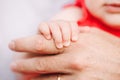 Closeup of baby fingers holding father parent hand palm. Baby trust and confidence in adult parent. Parent holding child daughter