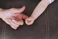 Closeup of a baby holding father`s finger at home. Family and love concept Royalty Free Stock Photo