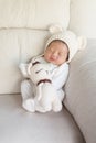 Closeup a baby sleeping comfortably on sofa with bear doll Royalty Free Stock Photo