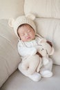 Closeup a baby sleeping comfortably on sofa with bear doll Royalty Free Stock Photo