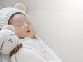 Closeup a baby sleeping comfortably on sofa with bear doll Royalty Free Stock Photo