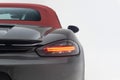 Closeup of a back of a luxurious Ferrari car parked against a plain white background.