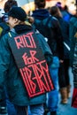 Closeup of the Back of a protester Wearing a Sign Saying Riot For Liberty
