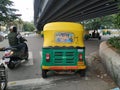 Closeup back view of Yellow and Green Color Auto Rickshaw stop at Signal. Famous Kannada Actor Challenging Star Darshan Movie