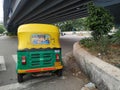 Closeup back view of Yellow and Green Color Auto Rickshaw stop at Signal. Famous Kannada Actor Challenging Star Darshan Movie