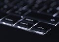 Closeup of backlit computer laptop keyboard selective focus on end key ideal for technology night hacker standout