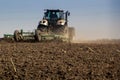 Closeup backside cultivator raises great dust on ploughed soil