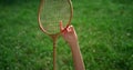 Closeup badminton racket in hands of smiling joyful girl lying on blanket.