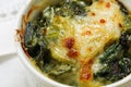 Closeup of baked spinach with cheese crust in a small casserole