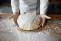 Closeup baker hands holding kneaded dough to prepare fresh bread